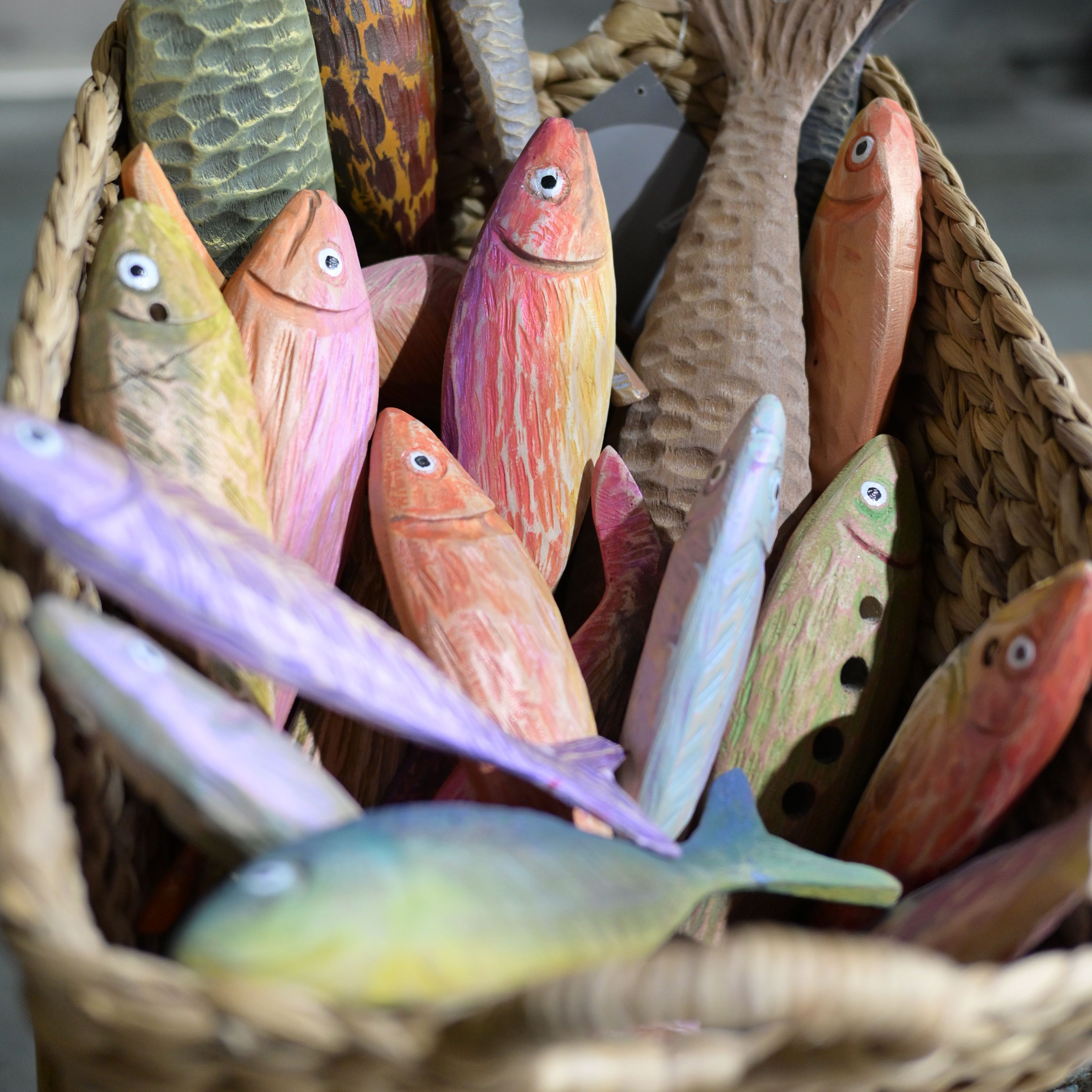 a basket of colorful, carved wooden fish
